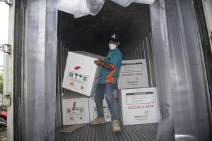 Petugas melakukan bongkar muat  vaksin COVID-19 Sinovac saat tiba di gudang vaksin (cold room) milik Dinas Kesehatan Provinsi Sumatera Selatan di Palembang, Senin (4/1/2020).